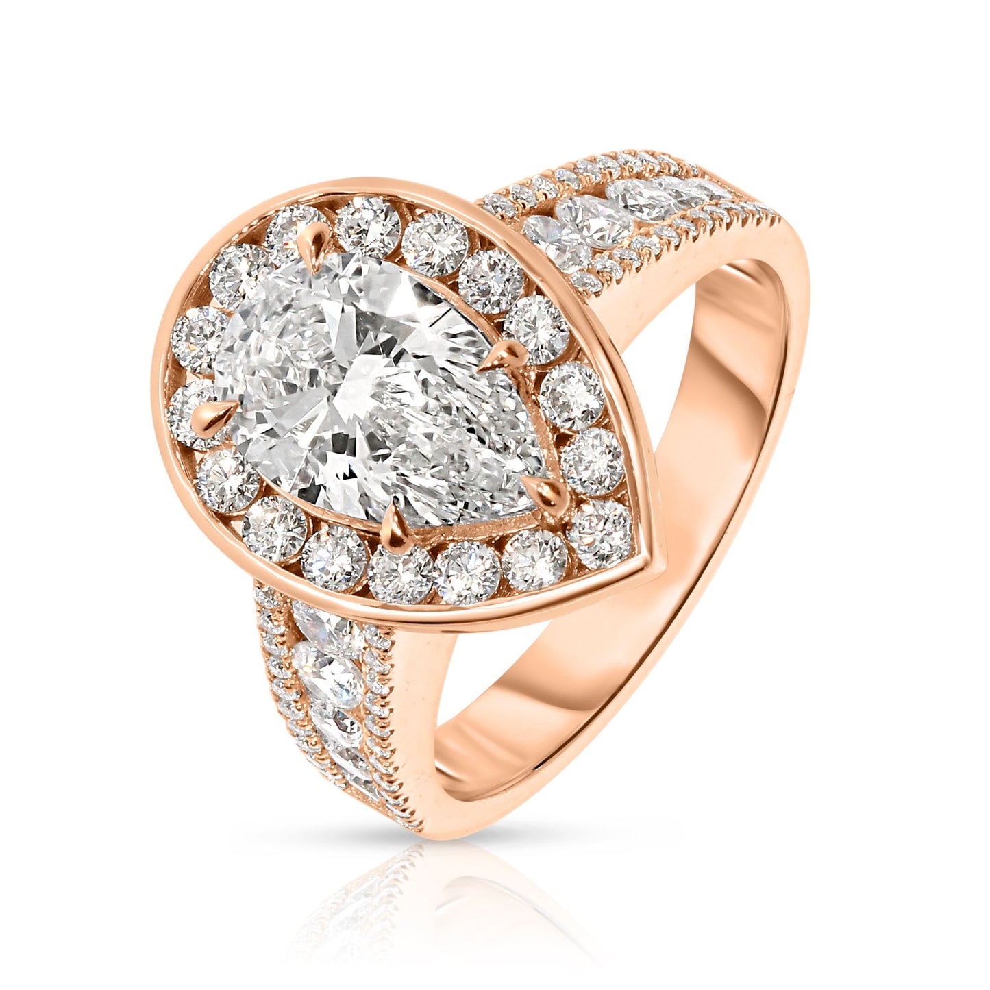 Experience the mystical elegance of the night sky with the "Tear of the Moon" Gold ring. This exquisite halo ring showcases a captivating pear-cut diamond at its heart, symbolizing the rare beauty of a moonlit tear. Encircled by a halo of shimmering diamonds, each stone glistens like stars against the Gold setting, evoking a celestial radiance that enchants and mesmerizes.