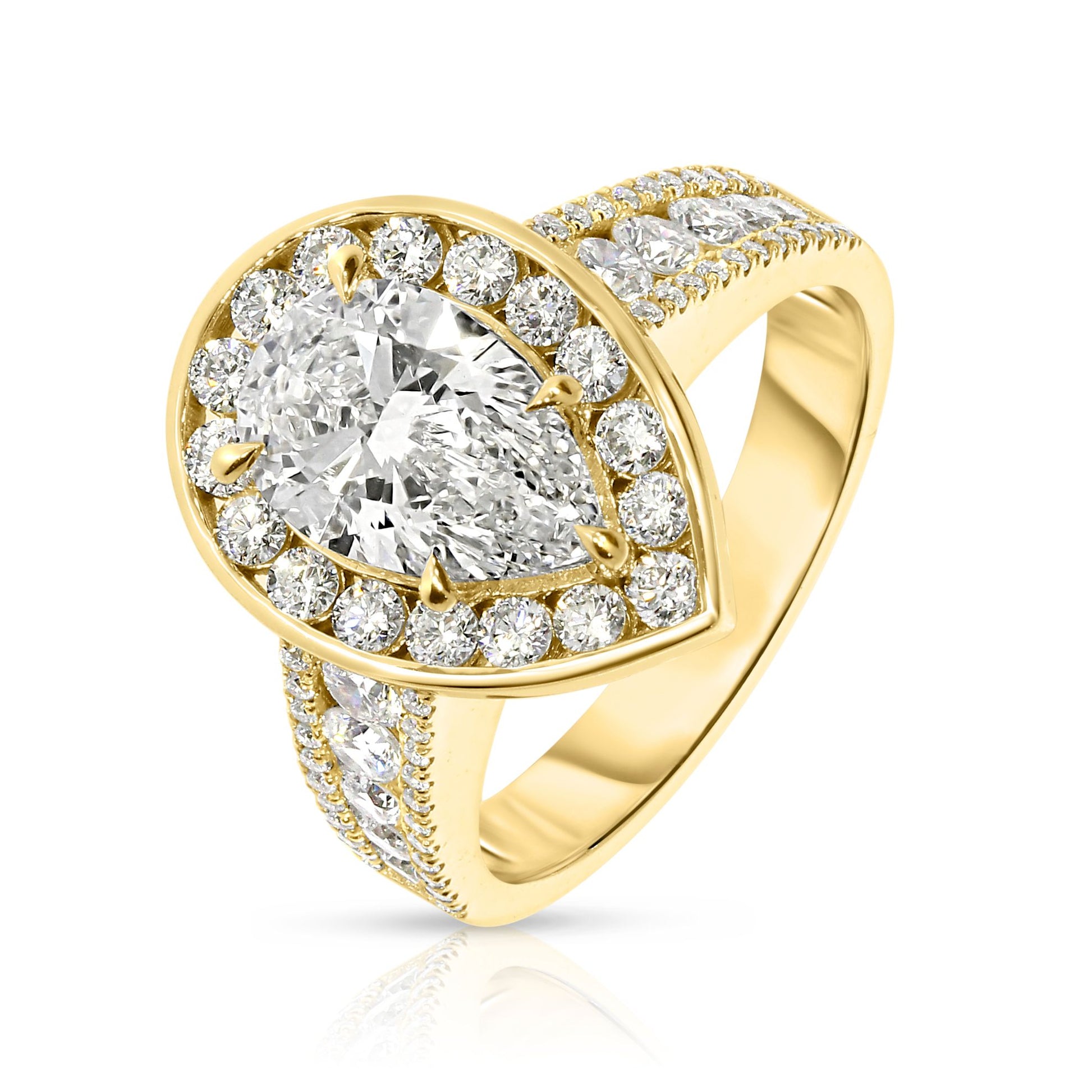 Experience the mystical elegance of the night sky with the "Tear of the Moon" Gold ring. This exquisite halo ring showcases a captivating pear-cut diamond at its heart, symbolizing the rare beauty of a moonlit tear. Encircled by a halo of shimmering diamonds, each stone glistens like stars against the Gold setting, evoking a celestial radiance that enchants and mesmerizes.