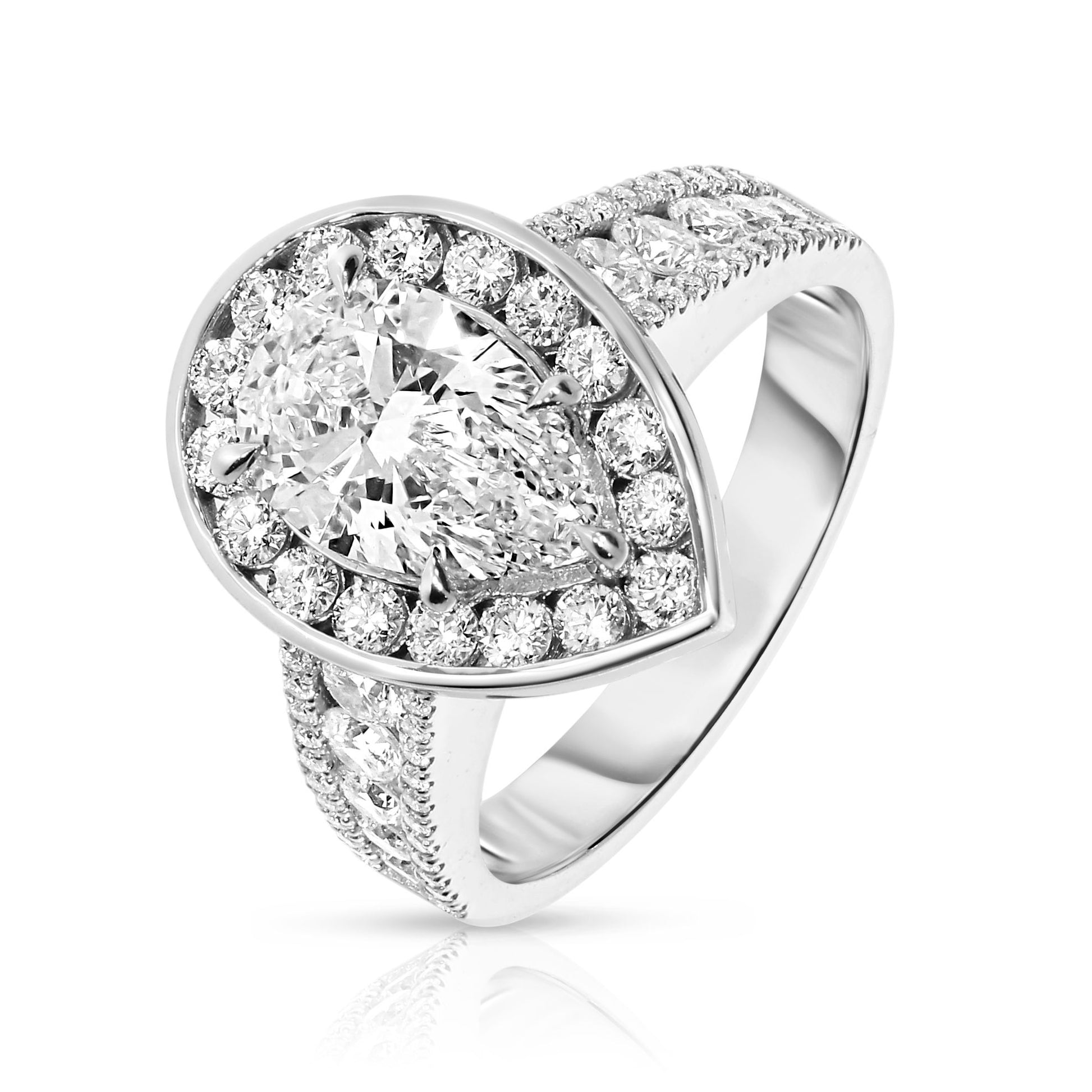 Experience the mystical elegance of the night sky with the "Tear of the Moon" Gold ring. This exquisite halo ring showcases a captivating pear-cut diamond at its heart, symbolizing the rare beauty of a moonlit tear. Encircled by a halo of shimmering diamonds, each stone glistens like stars against the Gold setting, evoking a celestial radiance that enchants and mesmerizes.